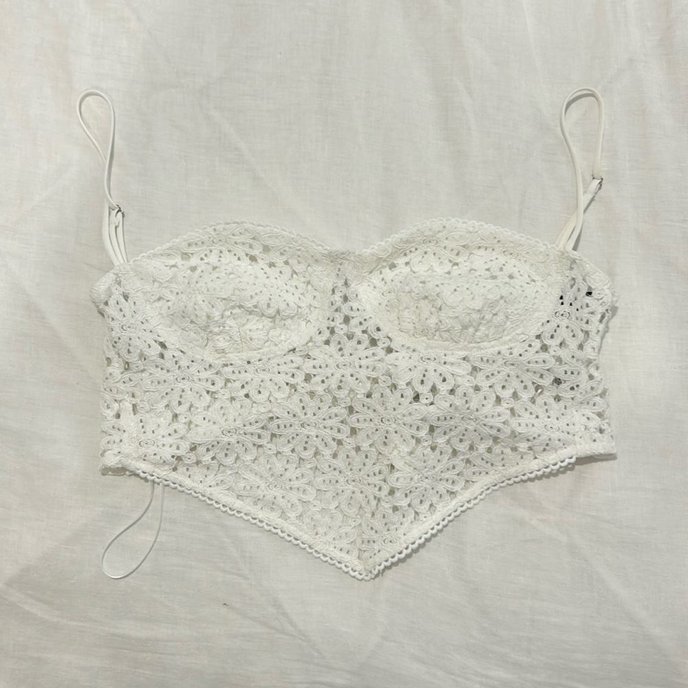 White lace going out top with a V hem and adjustable bow tie in the back.